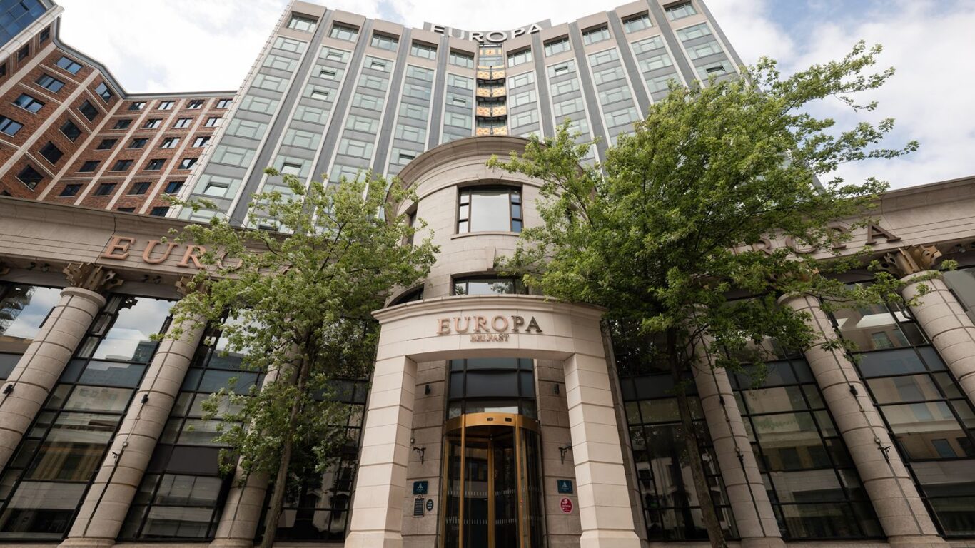 Elegant hotel entrance with grand columns, lush trees, and welcoming glass doors, promising a luxurious stay in the city centre.